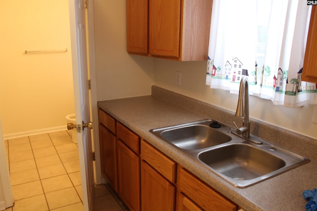 kitchen featuring light tile floors and sink