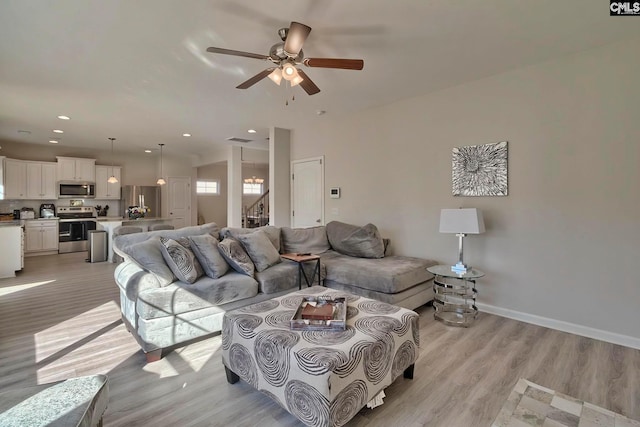 living room featuring light hardwood / wood-style floors and ceiling fan