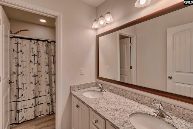 bathroom with dual vanity and hardwood / wood-style flooring