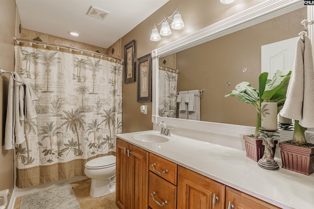 bathroom with tile flooring, toilet, and vanity