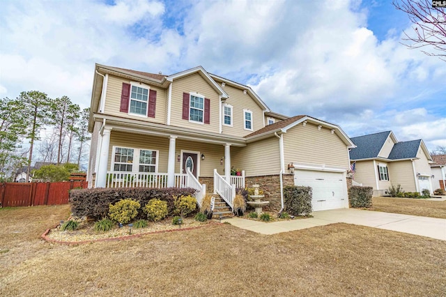 view of front of house featuring covered porch, a front yard, and a garage