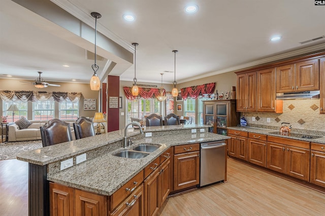 kitchen featuring pendant lighting, a wealth of natural light, a center island with sink, and ceiling fan with notable chandelier