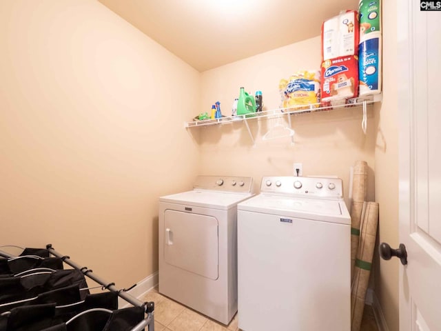 washroom with light tile flooring and washing machine and dryer