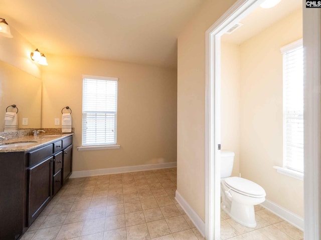 bathroom with toilet, tile floors, and vanity