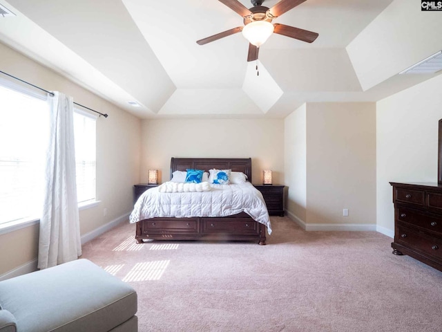 carpeted bedroom featuring ceiling fan and a tray ceiling