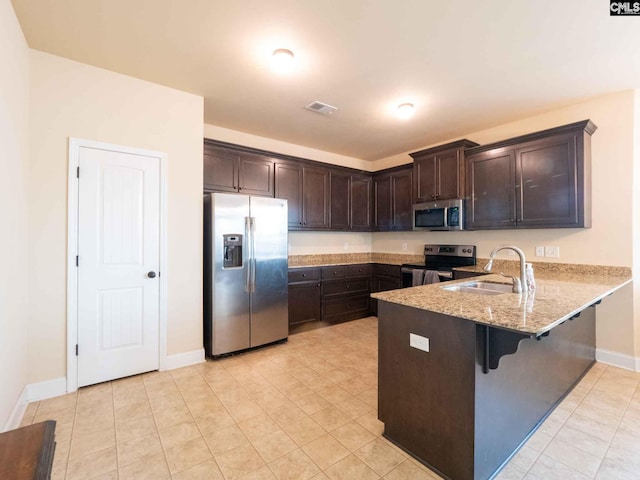 kitchen featuring dark brown cabinets, sink, light tile flooring, and stainless steel appliances