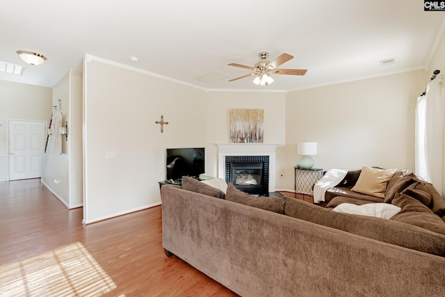 living room with crown molding, a fireplace, ceiling fan, and light hardwood / wood-style flooring