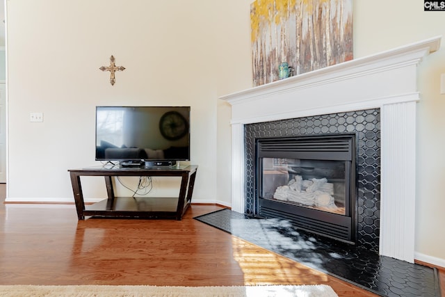 interior details featuring a tile fireplace and dark hardwood / wood-style floors