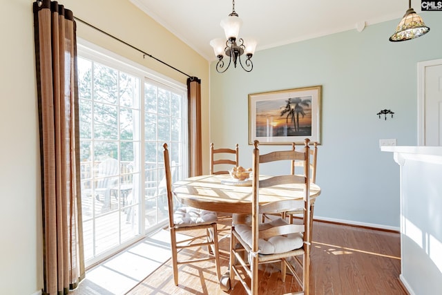 dining area featuring an inviting chandelier, light hardwood / wood-style floors, and ornamental molding