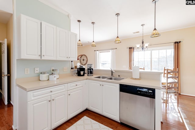 kitchen with pendant lighting, wood-type flooring, a notable chandelier, dishwasher, and sink