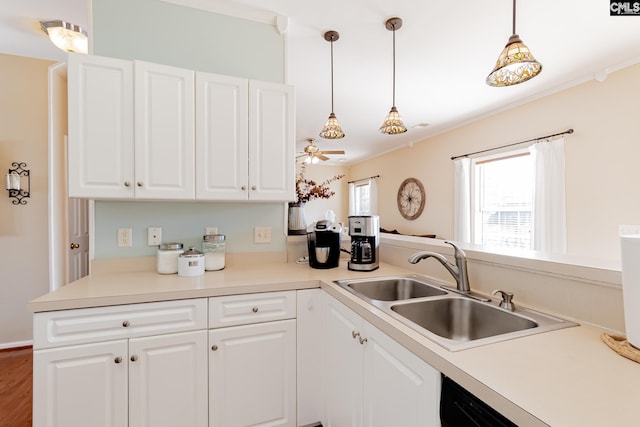 kitchen with crown molding, decorative light fixtures, white cabinetry, and sink