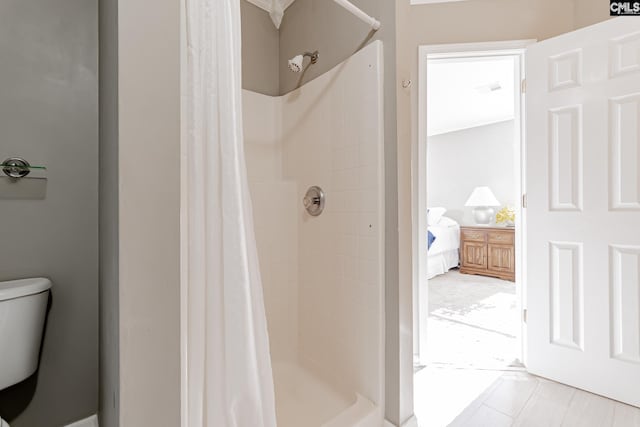 bathroom featuring toilet, tile flooring, and walk in shower