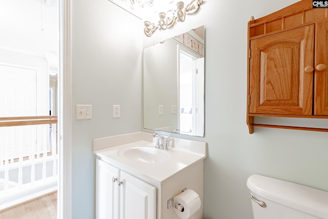 bathroom featuring vanity, wood-type flooring, and toilet