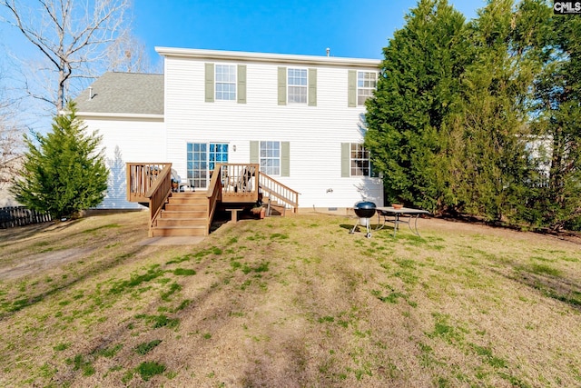 rear view of house with a wooden deck and a lawn