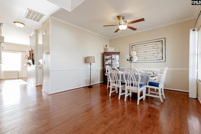 dining room featuring ornamental molding, ceiling fan, and dark wood-type flooring