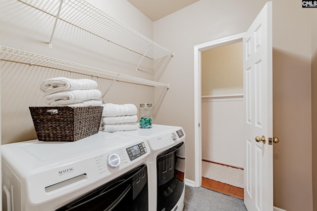 clothes washing area featuring independent washer and dryer and light colored carpet