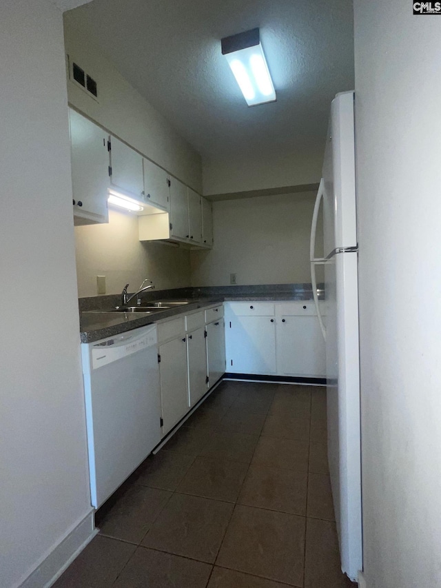 kitchen featuring sink, white appliances, dark tile floors, and white cabinets