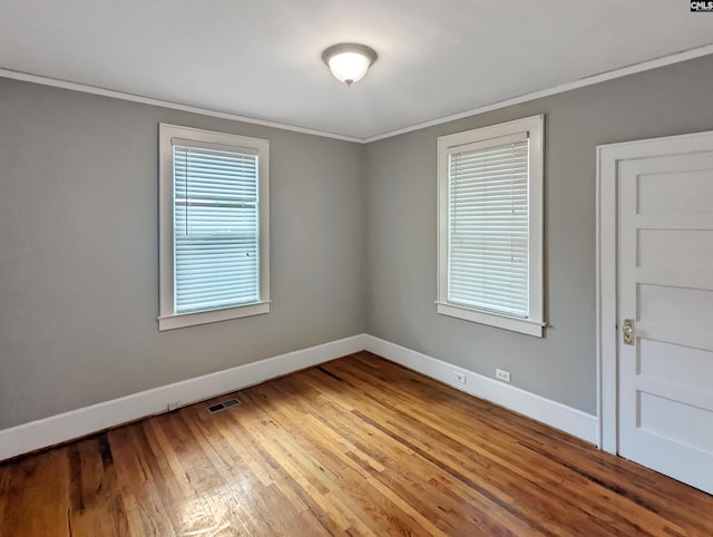 spare room with ornamental molding, light hardwood / wood-style floors, and a healthy amount of sunlight