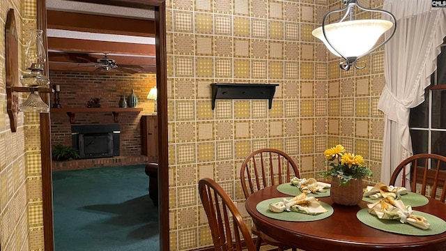 carpeted dining area with brick wall, ceiling fan, and a fireplace