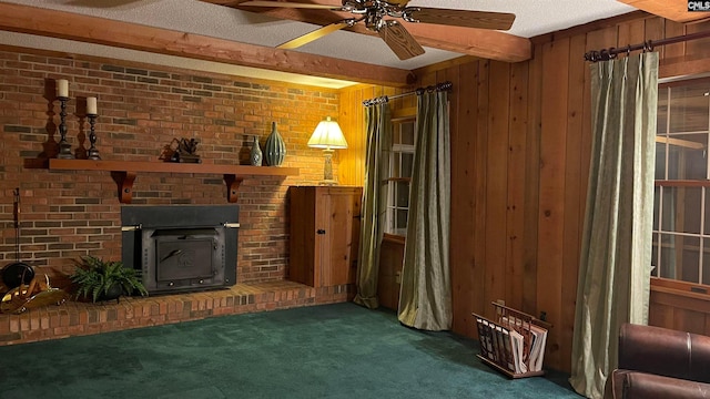 unfurnished living room with ceiling fan, a brick fireplace, wood walls, a textured ceiling, and dark carpet