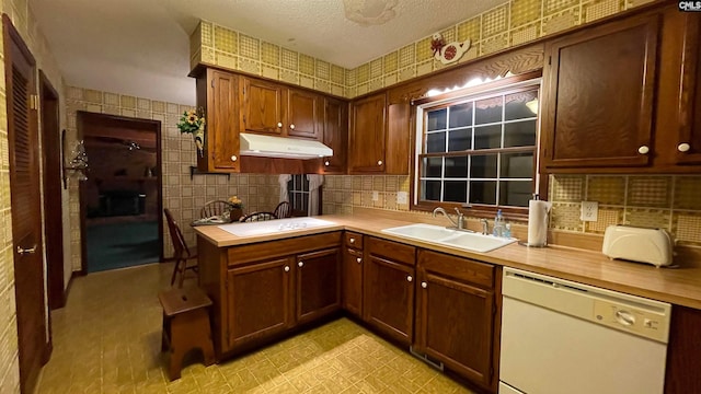 kitchen with stovetop, tasteful backsplash, light tile floors, dishwasher, and sink