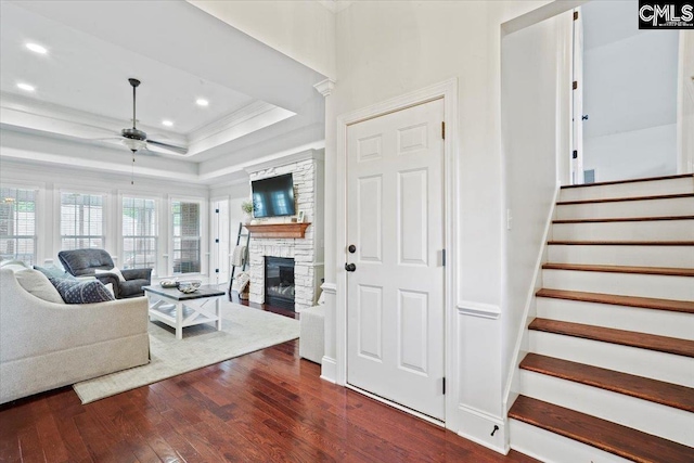 51 Swallowtail Ct, Columbia, SC 29229 - living room with dark hardwood / wood-style flooring, a stone fireplace, crown molding, ceiling fan, and a raised ceiling
