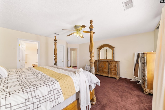 bedroom featuring ceiling fan, dark colored carpet, and ensuite bathroom