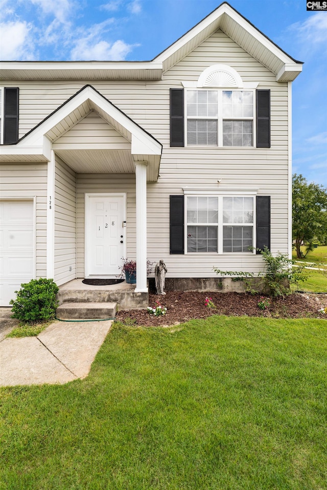 view of front of property with a front yard and a garage