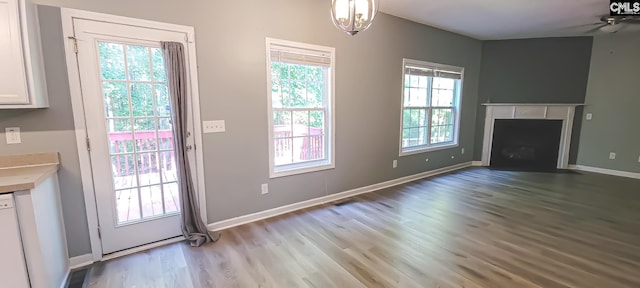 entryway with an inviting chandelier, light wood-type flooring, and a healthy amount of sunlight