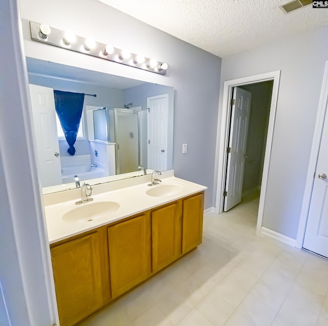 bathroom with separate shower and tub, double vanity, a textured ceiling, and tile floors