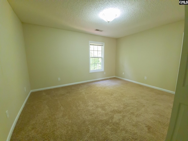 spare room with a textured ceiling and light colored carpet