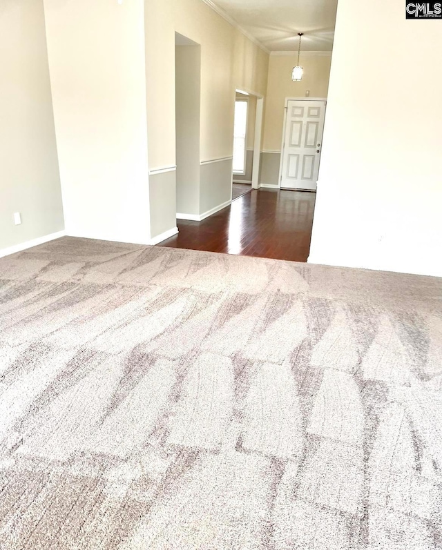 unfurnished room featuring crown molding and dark carpet