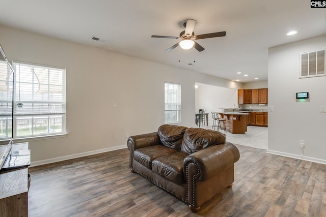 living room featuring sink, ceiling fan, and hardwood / wood-style flooring