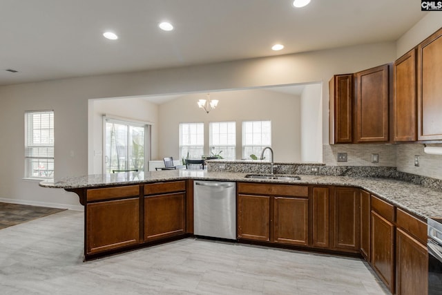 kitchen featuring stainless steel dishwasher, an inviting chandelier, stone counters, light tile floors, and sink