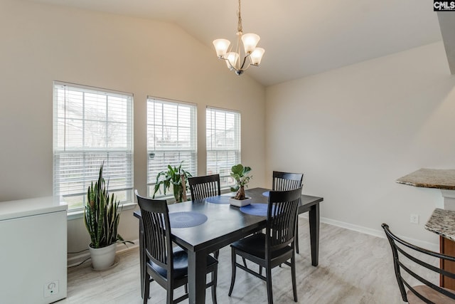 dining room featuring lofted ceiling, plenty of natural light, and an inviting chandelier