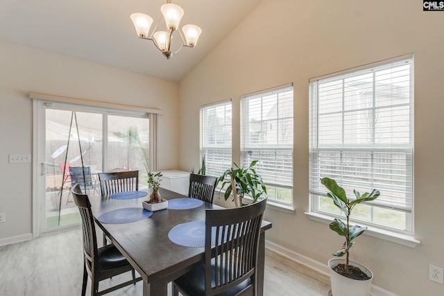 dining room with lofted ceiling, a chandelier, and light wood-type flooring