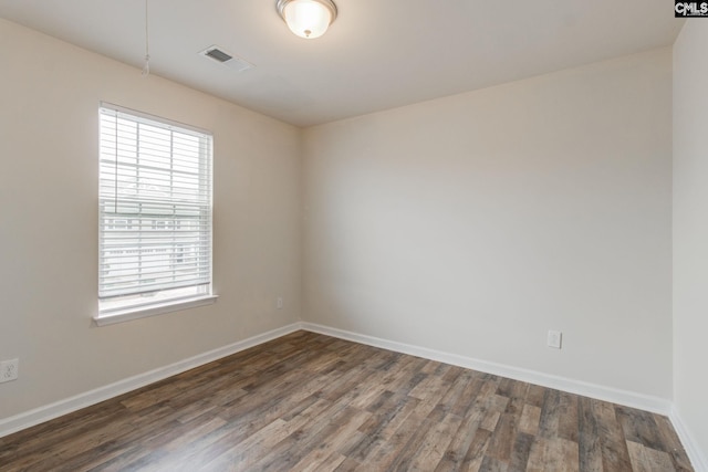 unfurnished room featuring a healthy amount of sunlight and dark hardwood / wood-style flooring