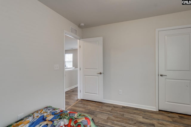 unfurnished bedroom with dark wood-type flooring