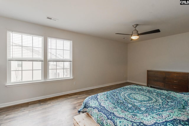 bedroom with ceiling fan, light hardwood / wood-style flooring, and multiple windows