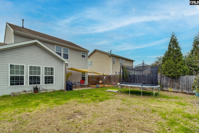 back of property featuring a patio, a trampoline, and a lawn