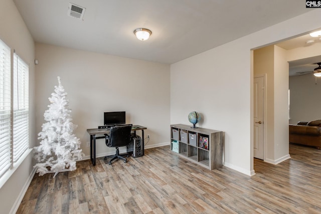 office with light hardwood / wood-style flooring and ceiling fan