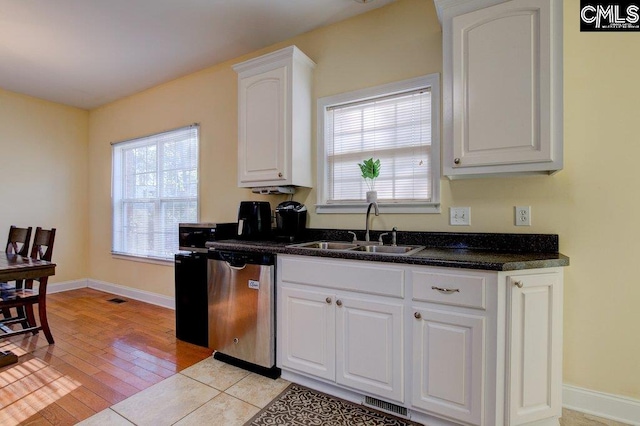 kitchen featuring dishwasher, white cabinetry, sink, and light wood-type flooring