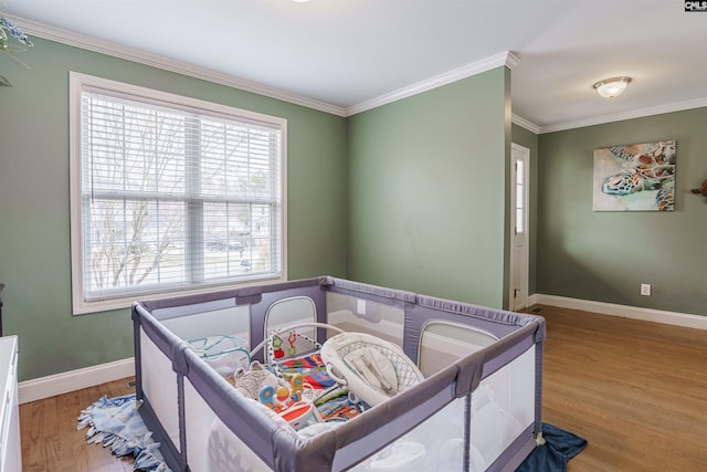 bedroom with ornamental molding, wood-type flooring, and multiple windows