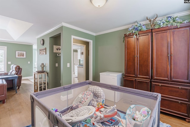 interior space with light hardwood / wood-style flooring, crown molding, and a skylight