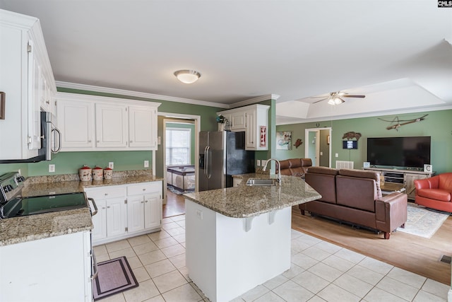 kitchen with electric stove, stainless steel fridge, ceiling fan, sink, and a tray ceiling