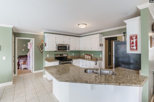 kitchen with light stone counters, kitchen peninsula, appliances with stainless steel finishes, and sink