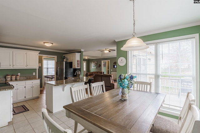 dining room with sink, ceiling fan, light tile floors, and a wealth of natural light