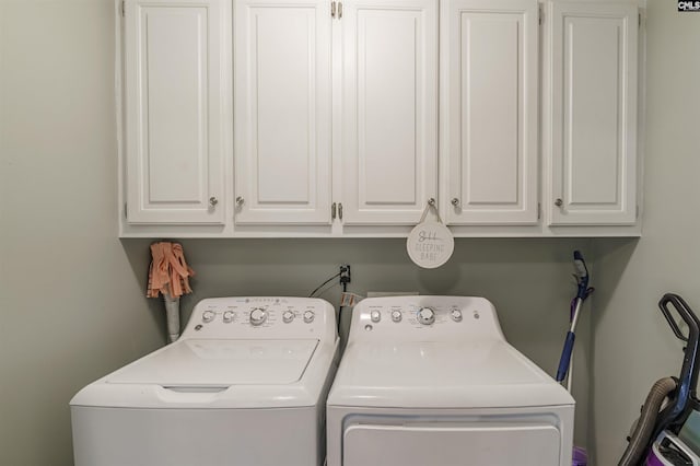 washroom with cabinets and washing machine and clothes dryer