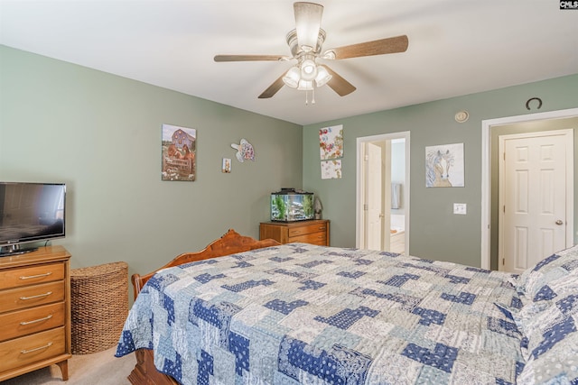 bedroom with ceiling fan, ensuite bathroom, and light colored carpet