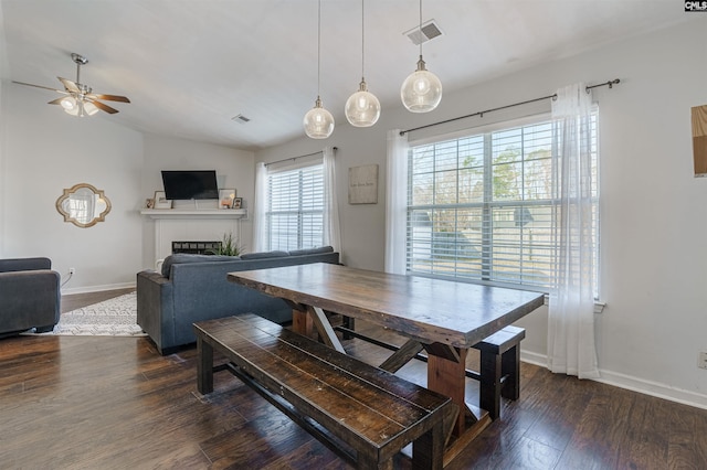 dining area with vaulted ceiling, ceiling fan, and dark wood-type flooring